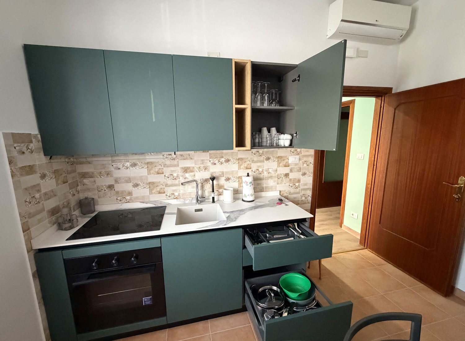 Cucina moderna con forno, piano cottura e utensili nella Casa Vacanze Antea