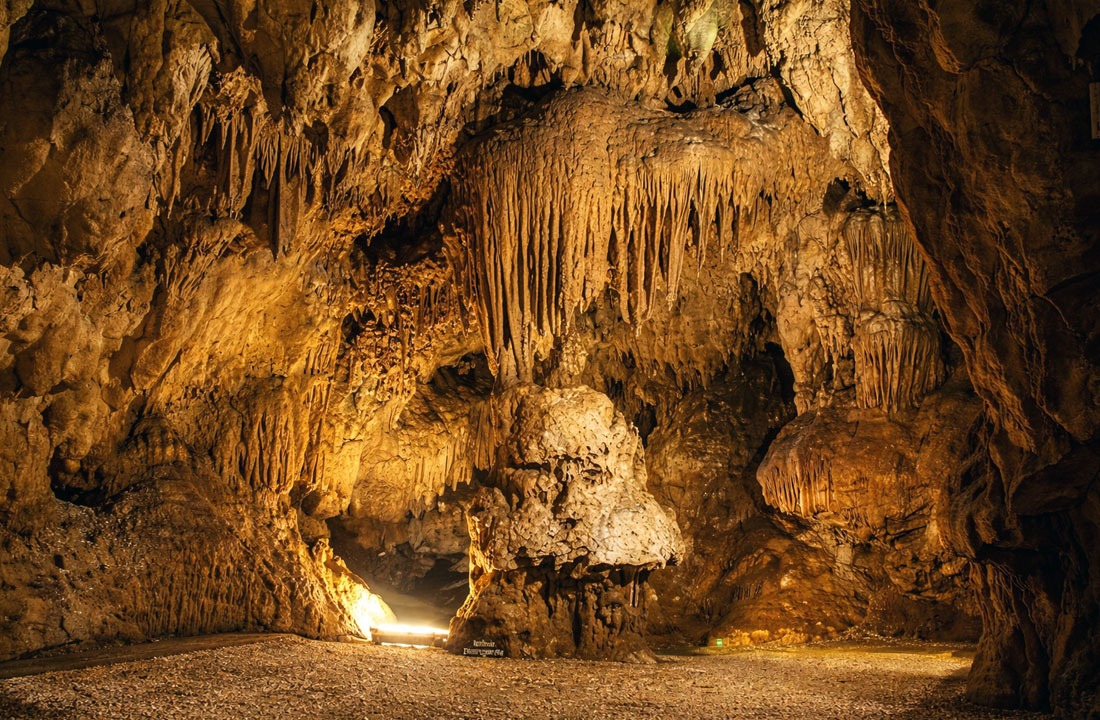 Interno delle Grotte di Pastena con stalattiti e stalagmiti illuminate nel Lazio